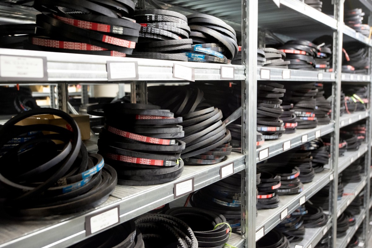 Storeroom shelving stocked with labeled drive belts